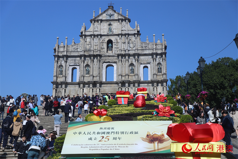 大三巴牌坊前立起慶祝澳門回歸祖國25周年的招牌。（人民網(wǎng) 吳宇揚揚 攝）